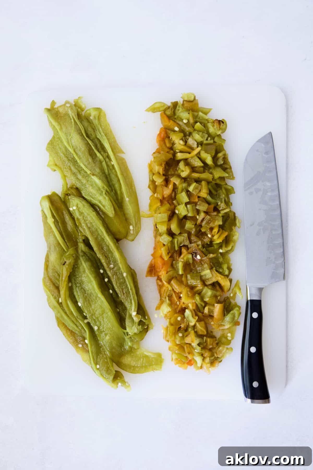Hatch Green Chiles: Roast and Freeze for Year-Round Enjoyment 11 Seeded and roasted Hatch green chiles on a white cutting board, with half of them diced into small pieces.