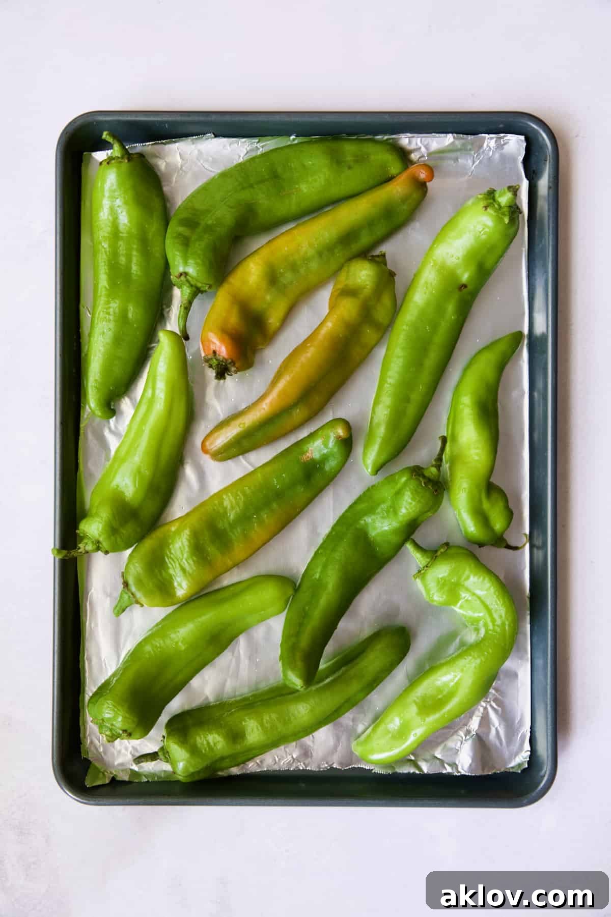 Hatch green chiles on rimmed sheet pan before being roasted.
