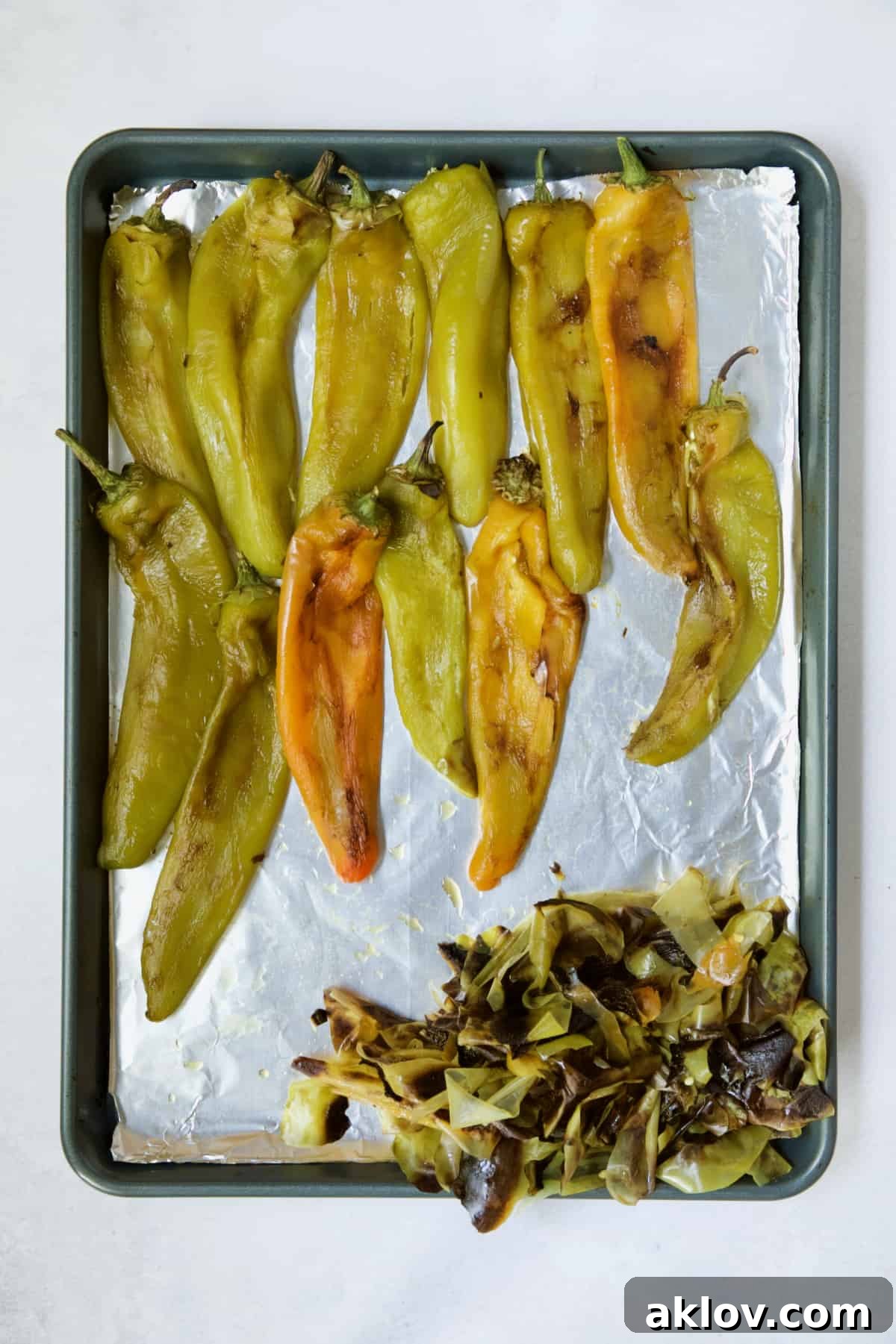 Hatch Green Chiles: Roast and Freeze for Year-Round Enjoyment 9 Roasted and peeled Hatch green chiles neatly arranged on a rimmed baking sheet, showcasing their tender flesh.