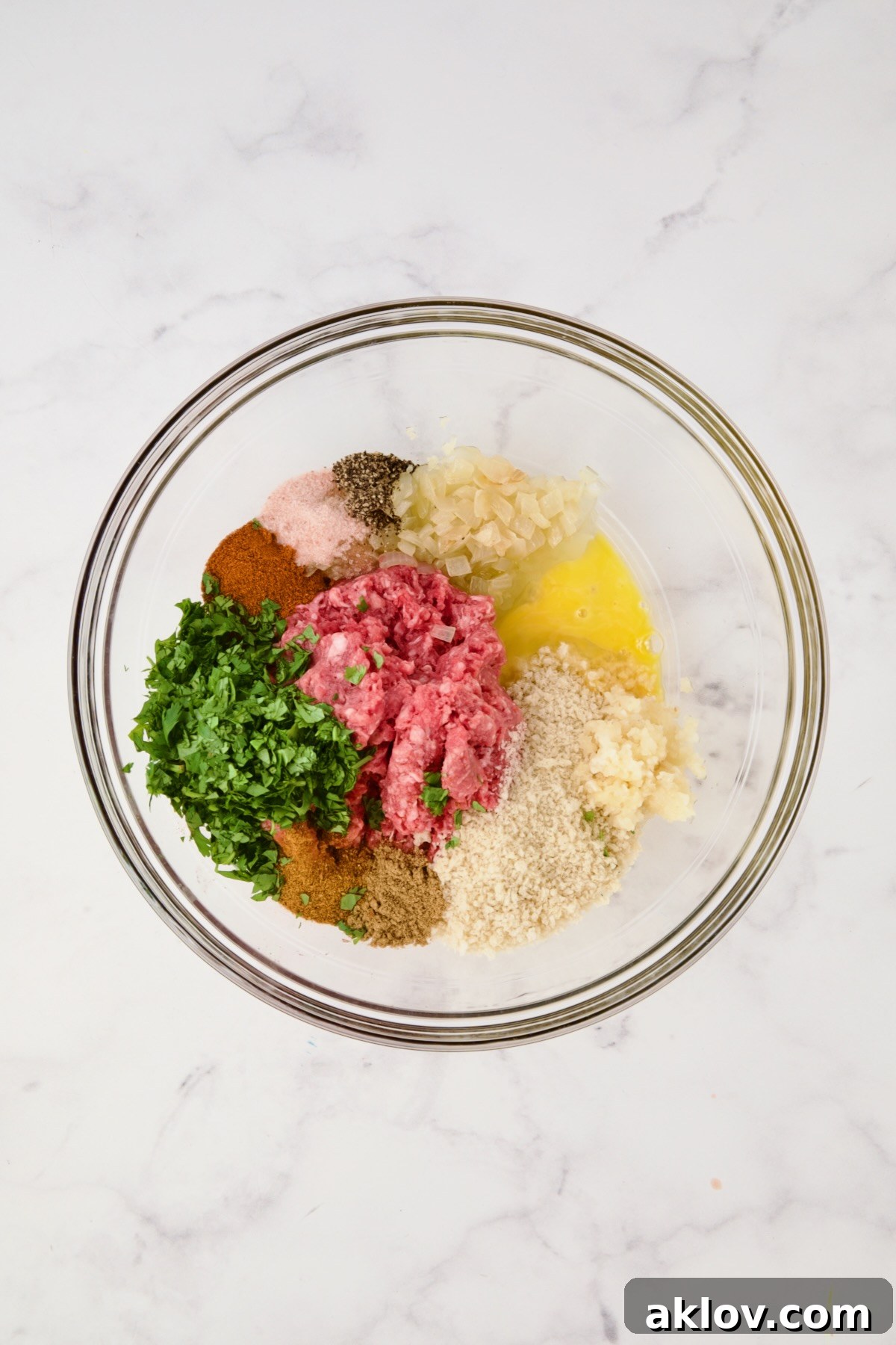Moroccan Spiced Kofta Stew 13 Ingredients for meatballs in glass bowl before being mixed together.