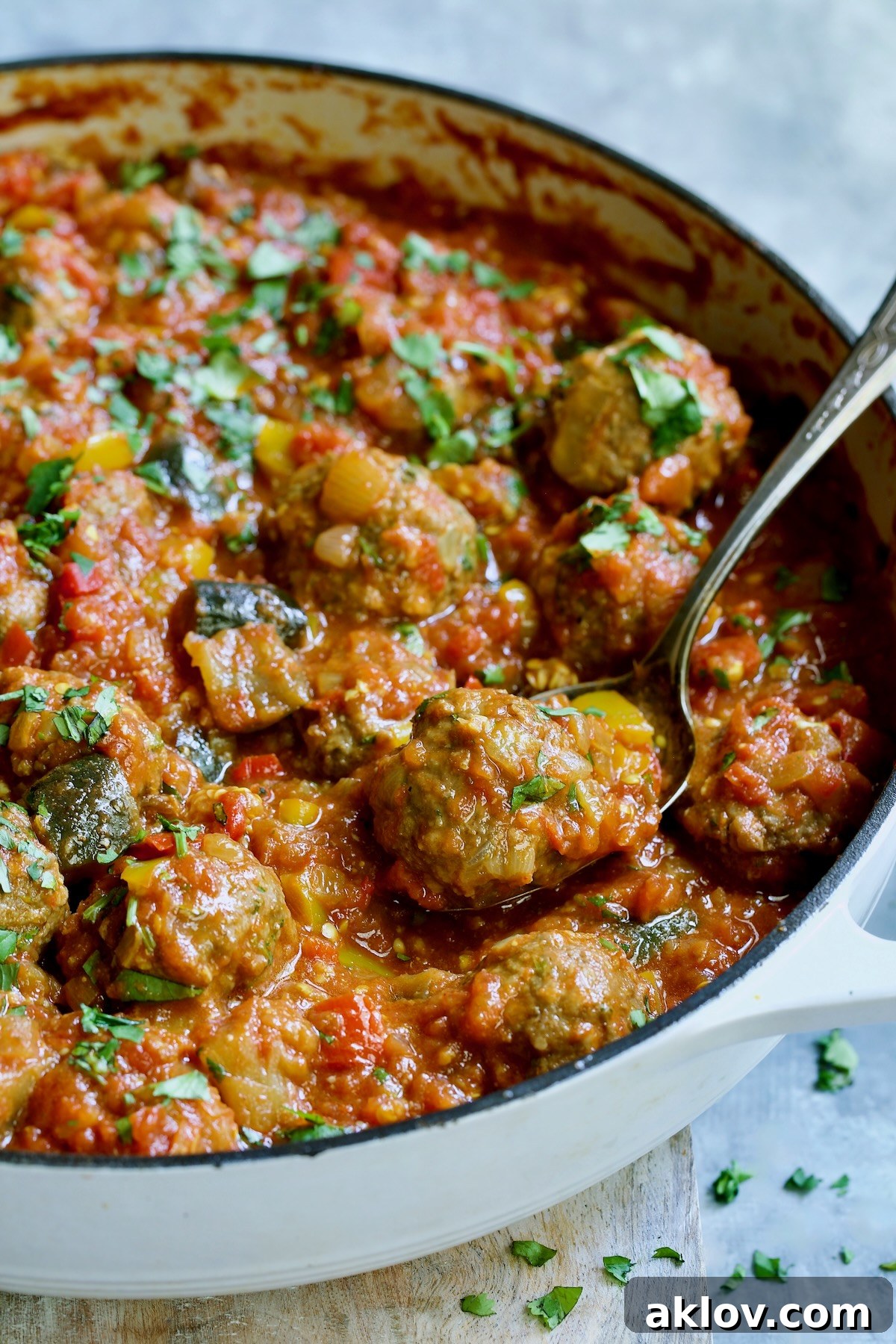 Moroccan Spiced Kofta Stew 20 Moroccan Meatball Stew in white enamel cast iron skillet with serving spoon.