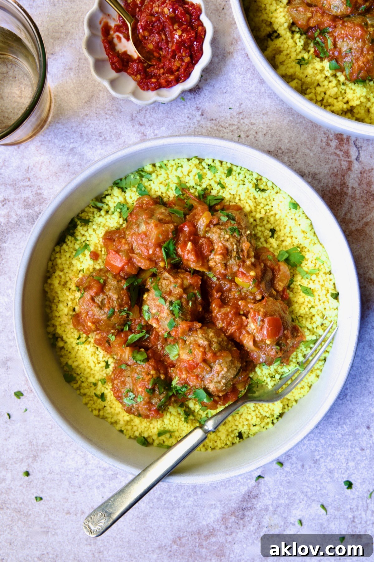 Moroccan Spiced Kofta Stew 21 One serving of Moroccan Meatball Stew in earthenware bowl over couscous.