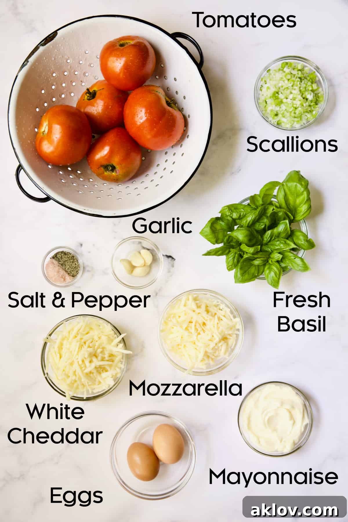 Ingredients for Crustless Southern Tomato Pie on white marble background.
