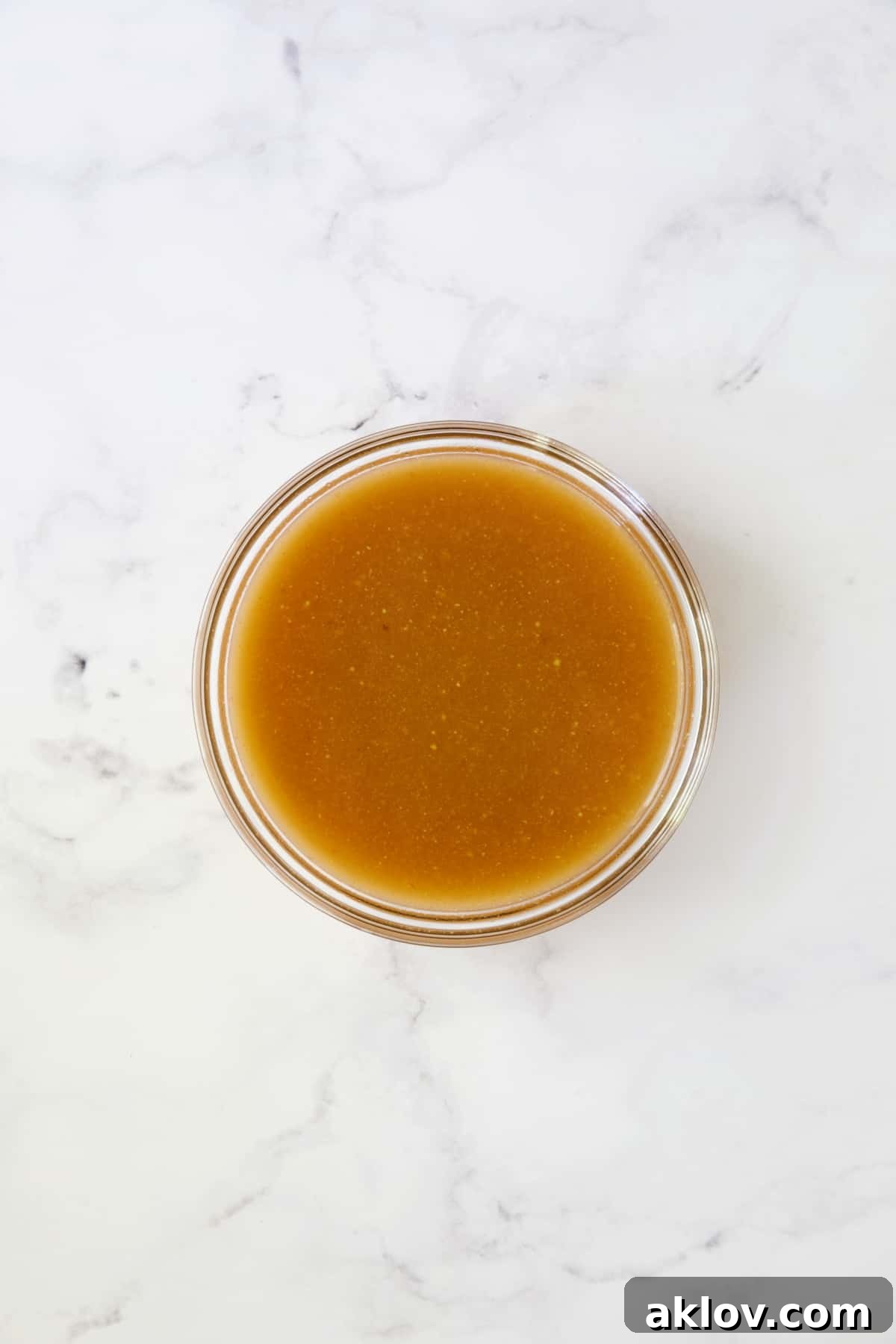 The savory-tangy braising sauce for cabbage, neatly prepared in a glass bowl before cooking.