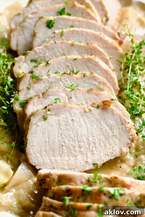Final presentation of Braised Pork Loin in Dijon Mustard Sauce, garnished with fresh thyme, perfect for serving.