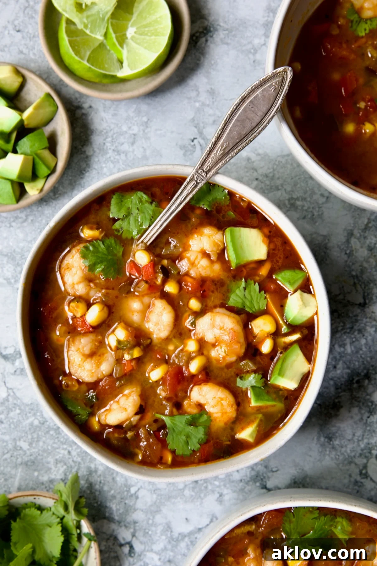 A steaming bowl of Mexican-inspired Shrimp and Corn Soup, garnished with fresh cilantro and a lime wedge, ready to be enjoyed.