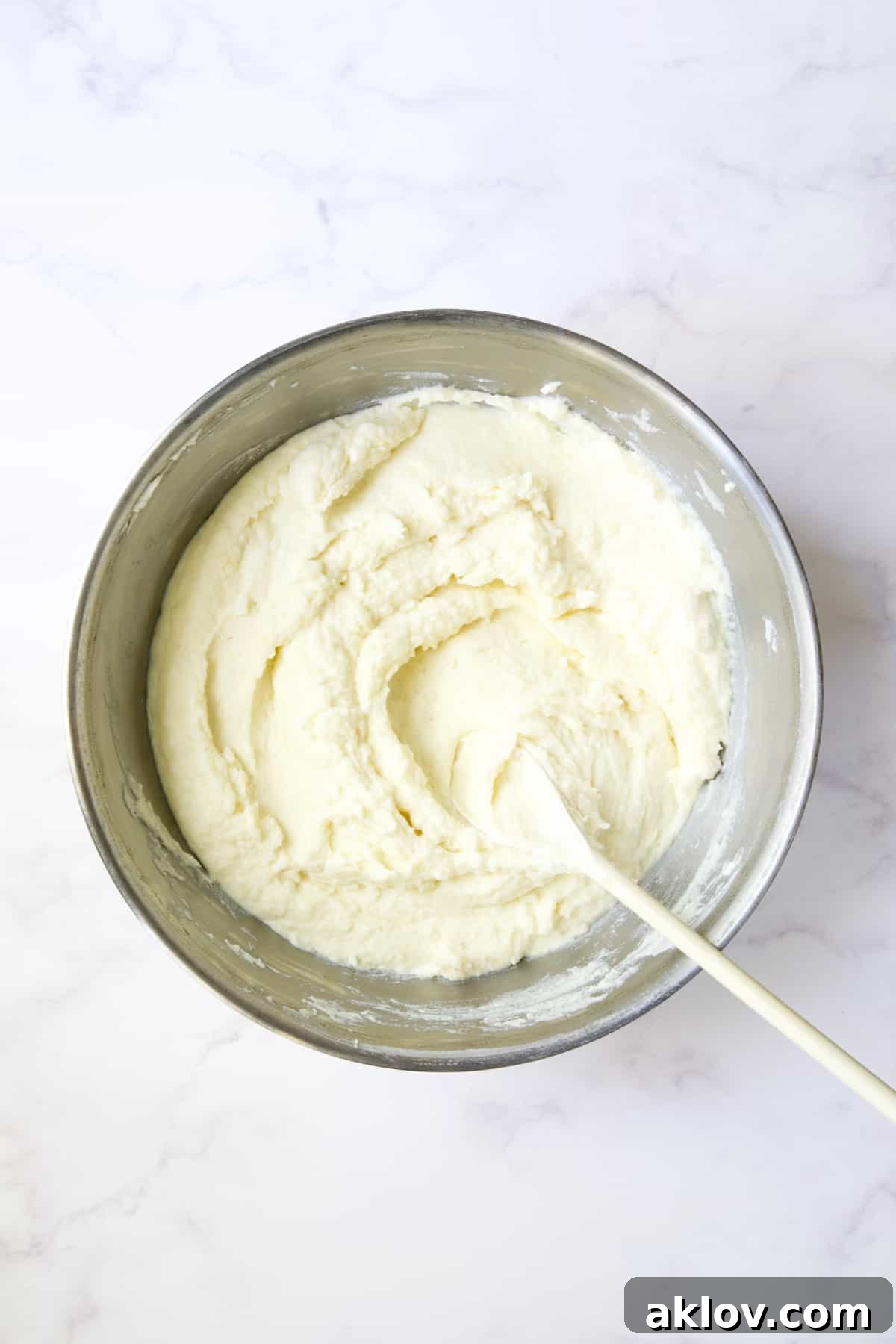 Beautifully blended mashed potatoes in a stainless steel bowl, exhibiting a smooth, creamy, and inviting texture.