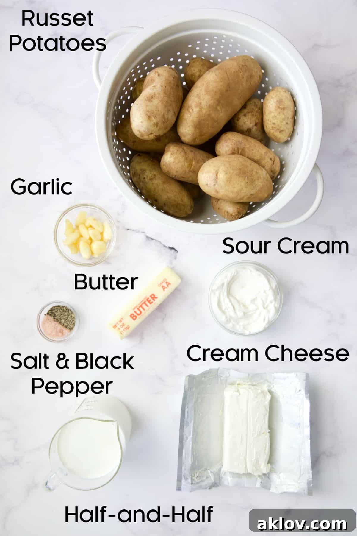 A flat lay of fresh ingredients for make-ahead mashed potatoes including russet potatoes, butter, sour cream, cream cheese, and half-and-half.