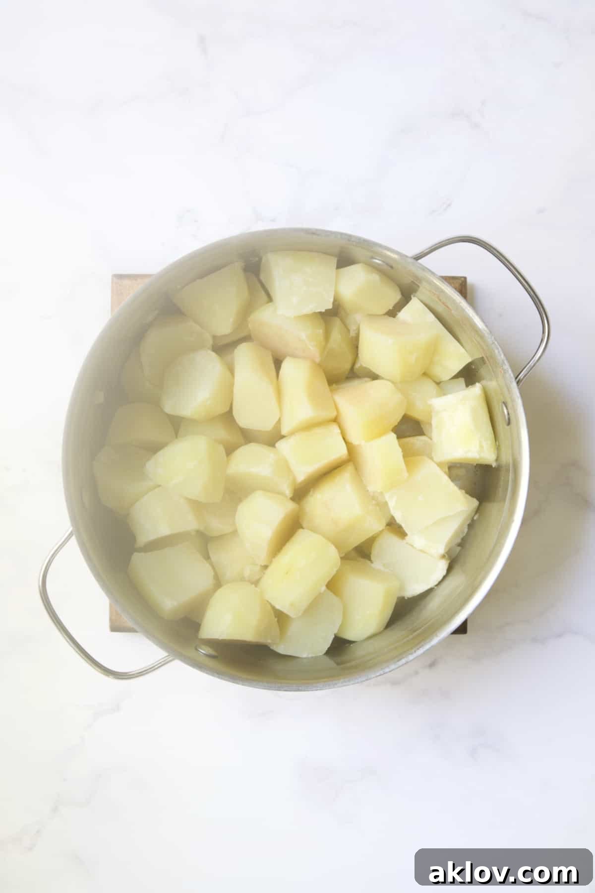Steaming, cooked potatoes and garlic in a pot after draining, drying out on the warm burner.