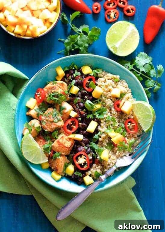 Cuban Chicken and Black Bean Quinoa Bowls garnished with lime wedges and cilantro.
