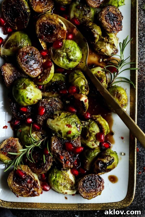 Pan-Seared Brussels Sprouts garnished with fresh rosemary and bright pomegranate arils.