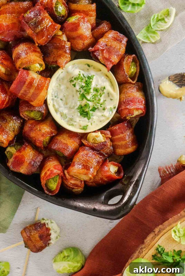 Balsamic Bacon-Wrapped Brussels Sprouts served in a black serving dish, glistening with glaze.