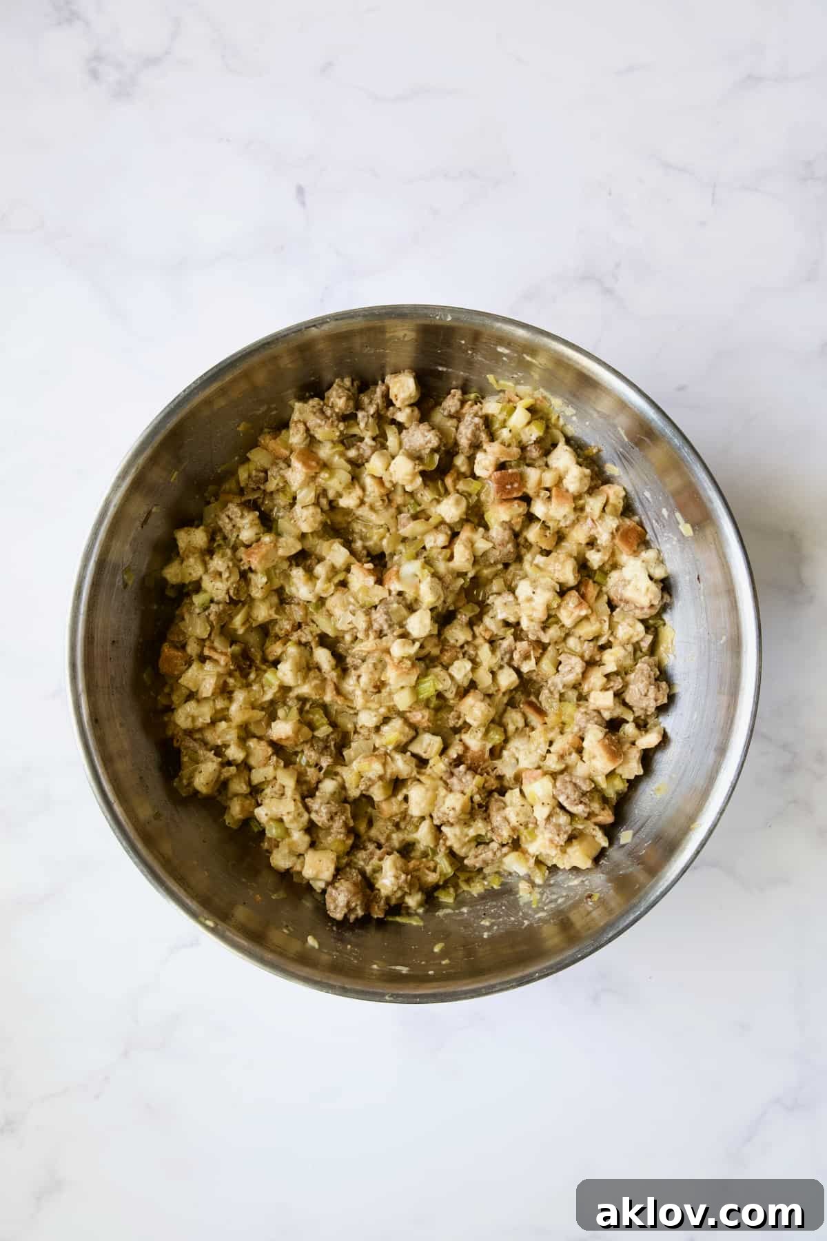 Aromatic Fennel and Leek Sausage Stuffing 10 Ingredients for Sausage Stuffing with Fennel and Leeks thoroughly mixed together in a stainless steel bowl.