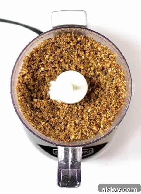 Close-up photo of the cornmeal, pecan, and spice mixture in a food processor, ready to be used as a crunchy coating.