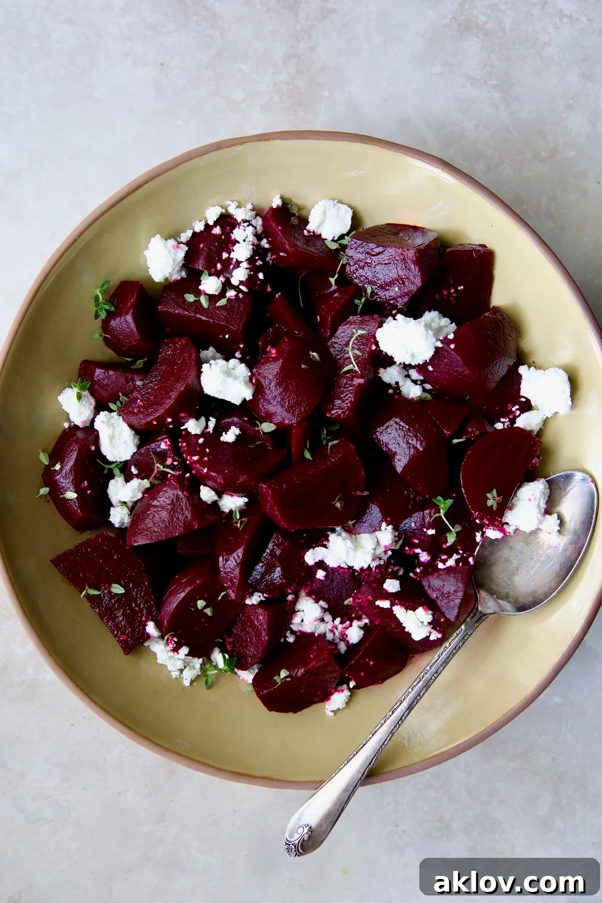 Roasted Beets with Red Wine Glaze in an earthenware serving bowl, garnished with goat cheese and fresh thyme.