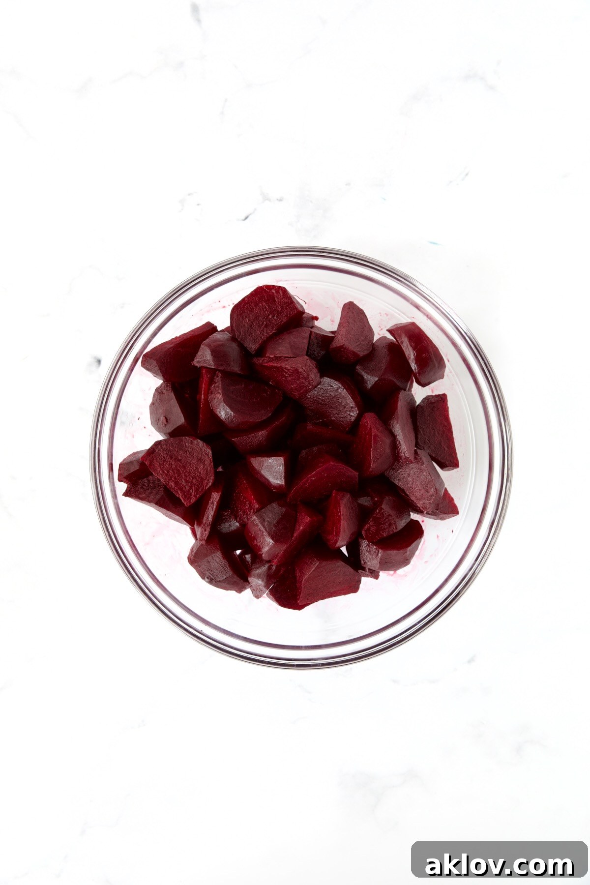 Roasted beets, neatly cut into wedges, in a glass bowl, ready for glazing.