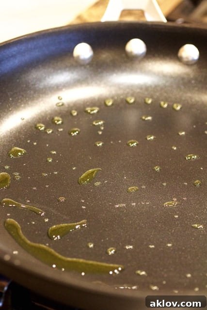 Pan-Seared Scallops with Vibrant Balsamic Tomato Salsa 9 Photo showing oil being heated in a nonstick skillet.