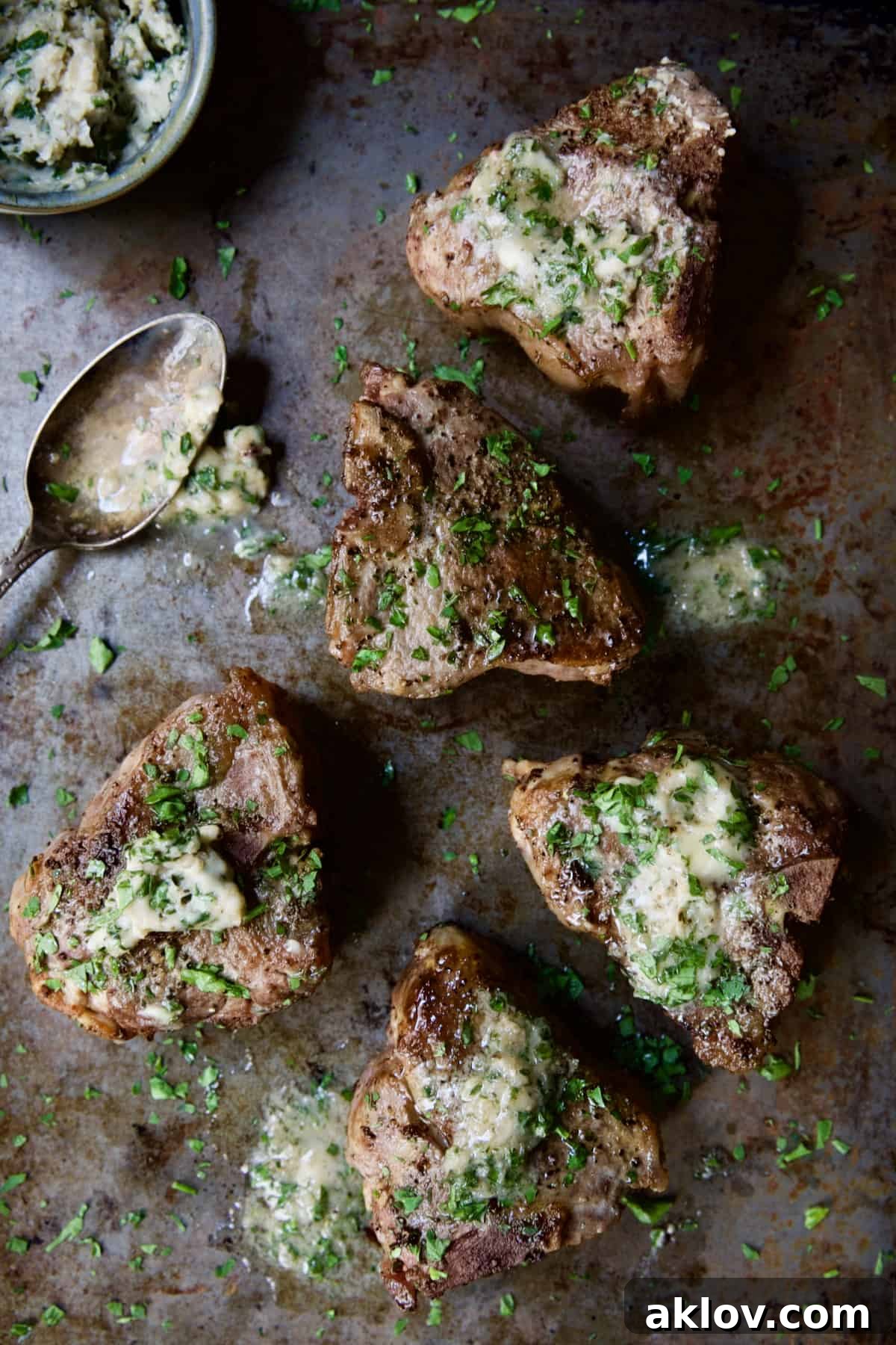 Perfectly Seared Lamb Chops with Melting Anchovy Butter on a baking sheet.
