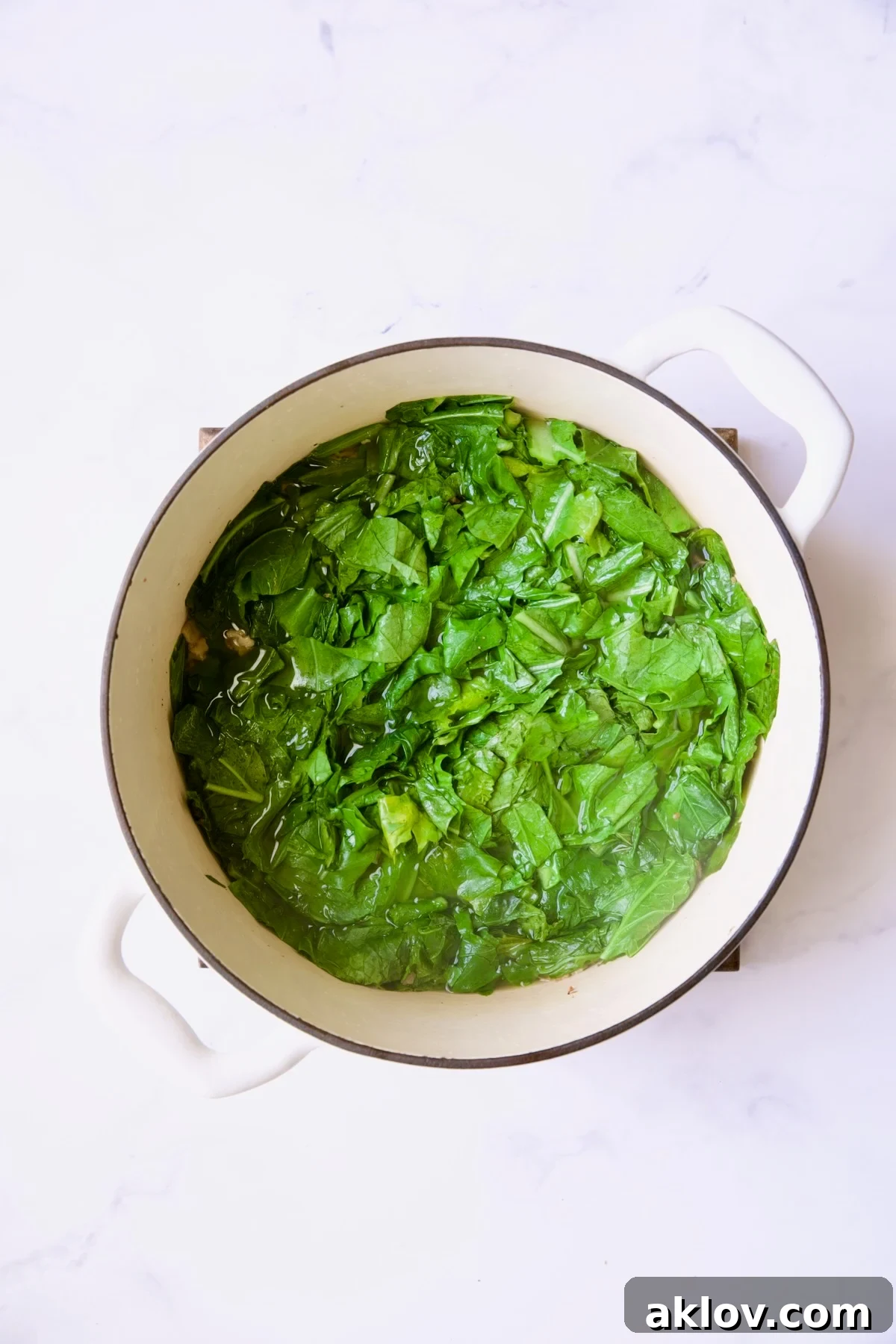 Greens in white Dutch oven before being cooked.