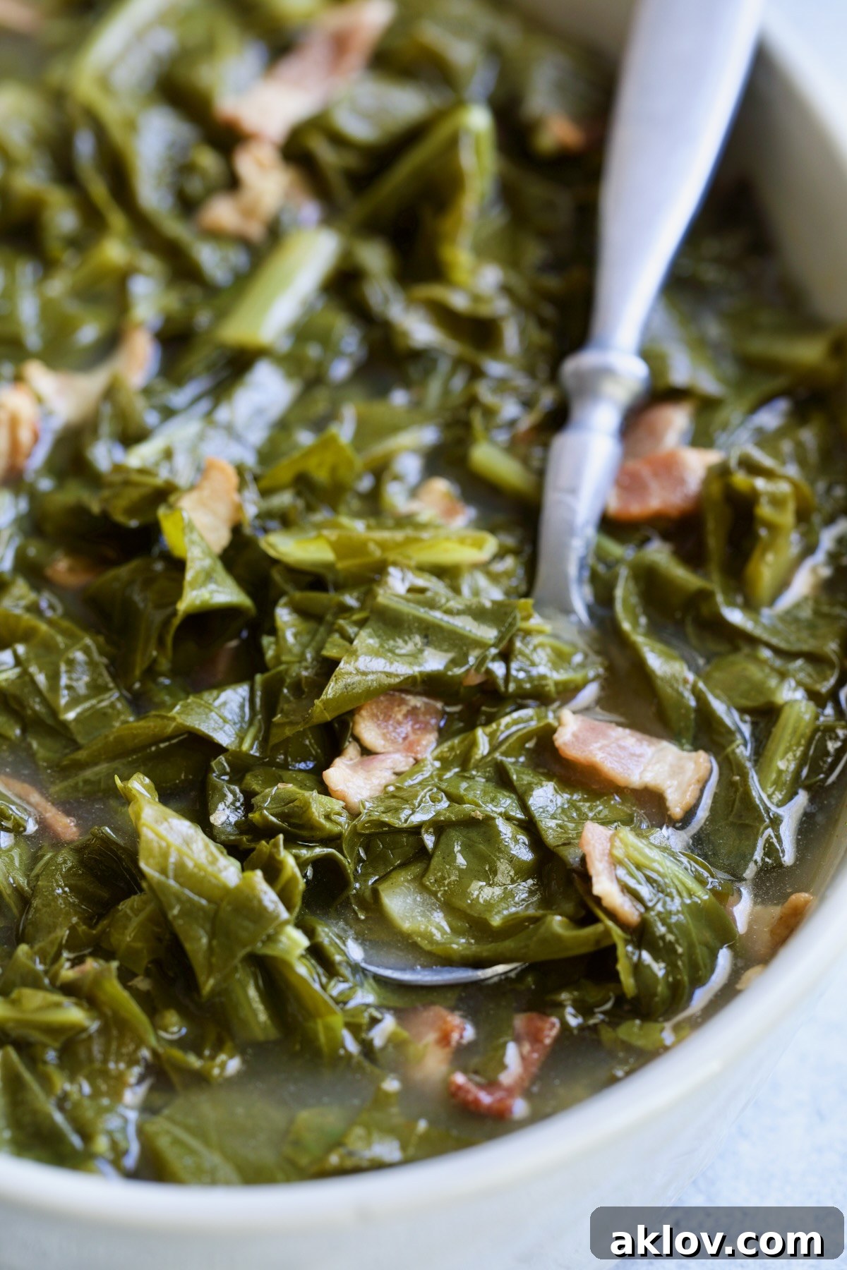Braised Southern Greens in bowl with spoon scooping some up.