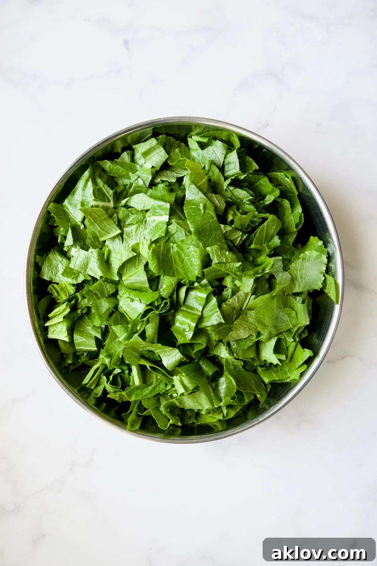 Uncooked greens in stainless steel bowl.