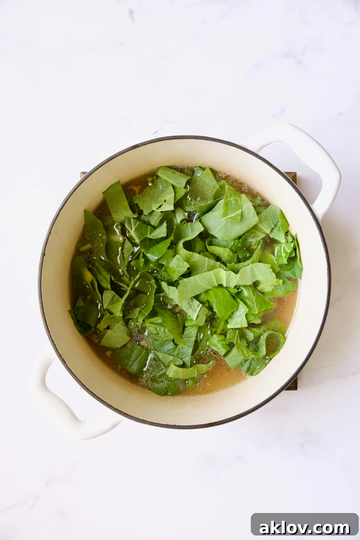 Greens in white Dutch oven before being cooked.