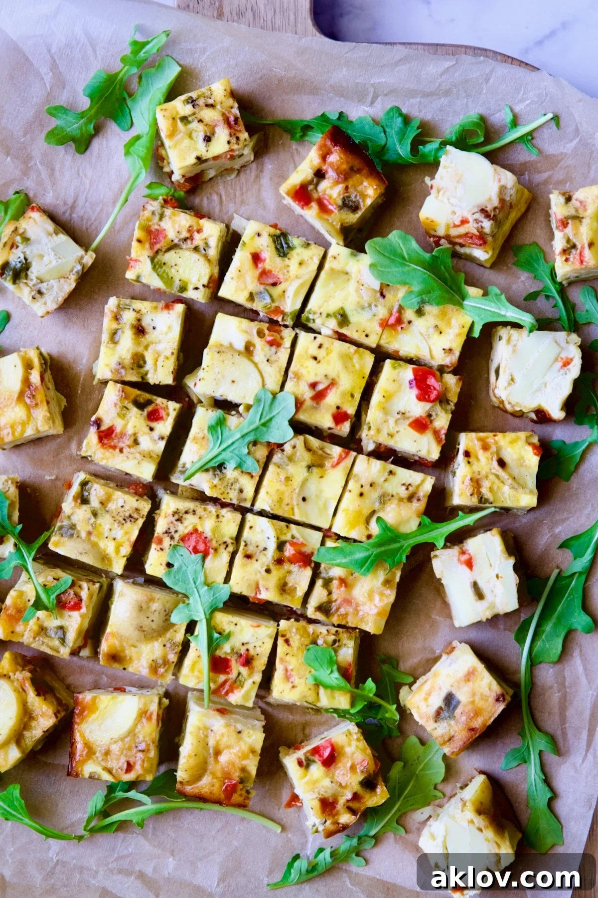 Oven-Baked Spanish Tortilla on cutting board garnished with arugula.