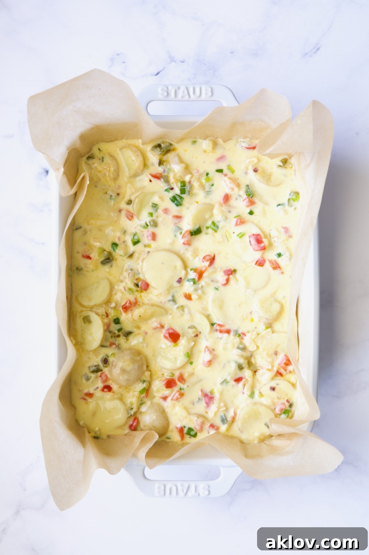 Tortilla in white baking dish before being baked.
