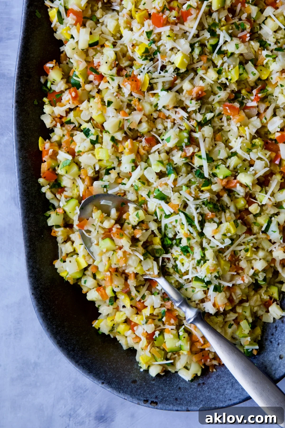 Garlic Parmesan Roasted Riced Veggies 3 Garlic Parmesan Roasted Vegetable Rice on platter with serving spoon, highlighting the texture and colors.