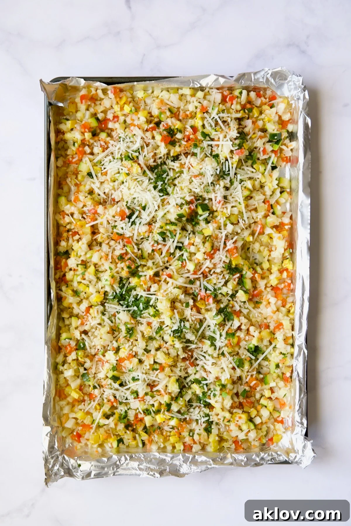 Garlic Parmesan Roasted Riced Veggies 10 Garlic Parmesan Roasted Vegetable Rice on aluminum foil-lined sheetpan, after combining all vegetables.