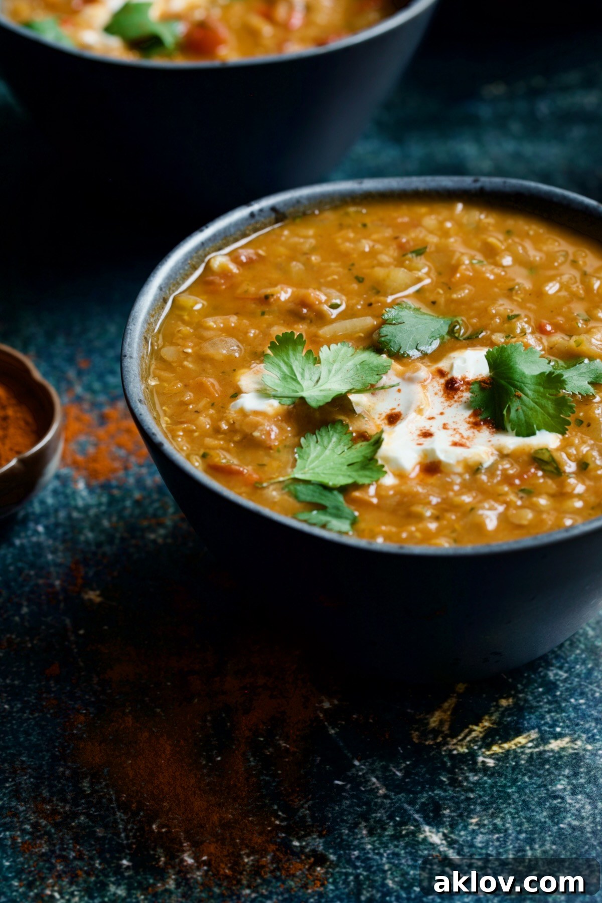 Bowl of Ethiopian Red Lentil Vegetable Soup on blue distressed background.
