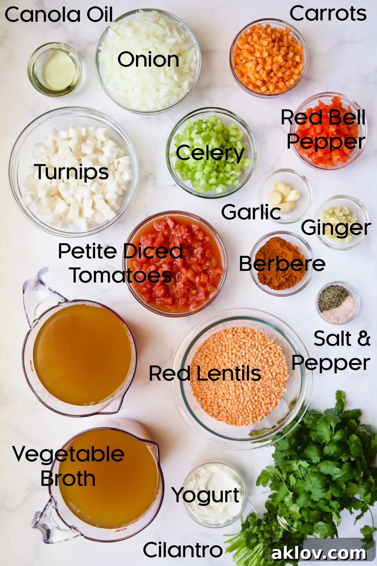 Assorted fresh ingredients for Ethiopian Red Lentil and Vegetable Stew, neatly arranged in small glass bowls, including lentils, spices, and chopped vegetables.