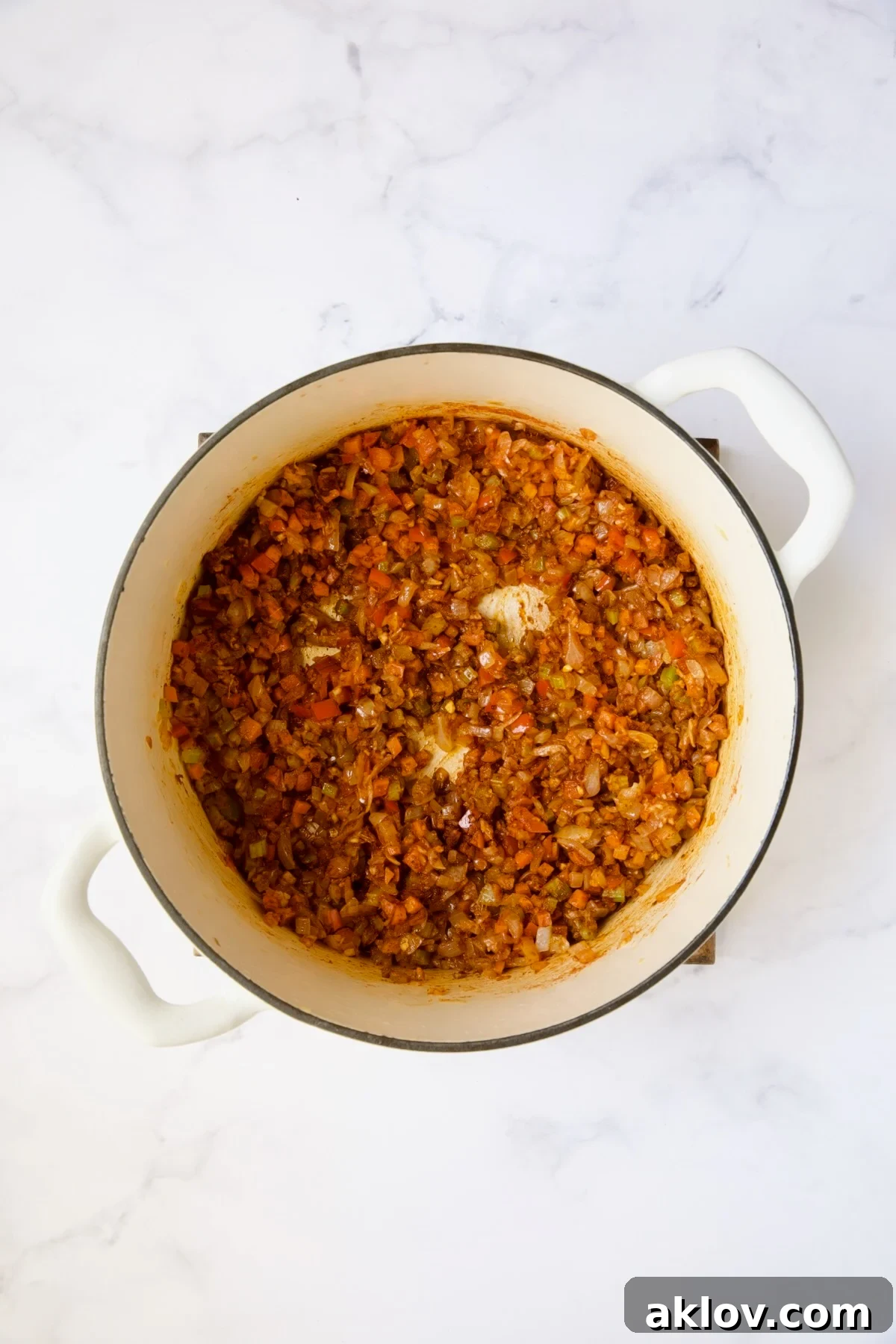 The vibrant sautéed vegetables now thoroughly coated and infused with the aromatic berbere spice, simmering gently in the white Dutch oven.