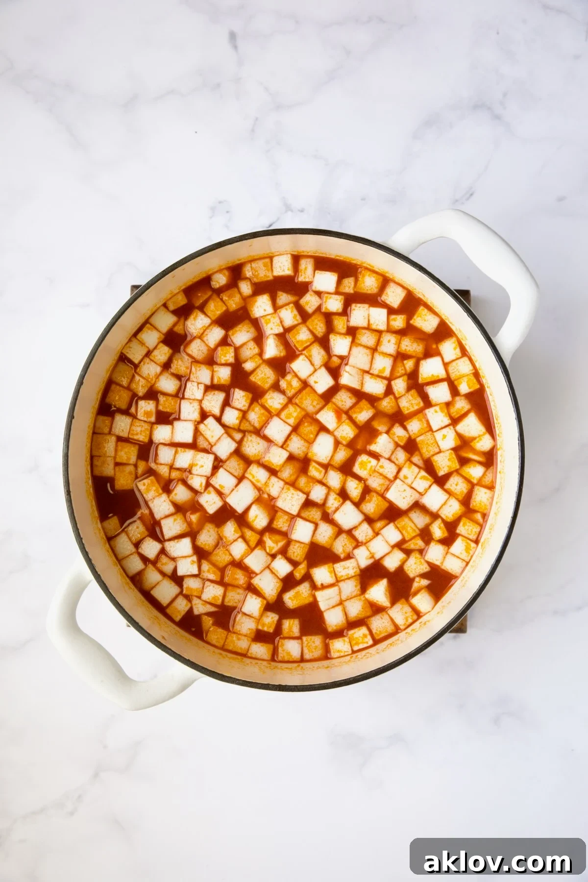 The hearty soup simmering gently in a white Dutch oven, with turnips freshly added and perfectly integrated into the broth.