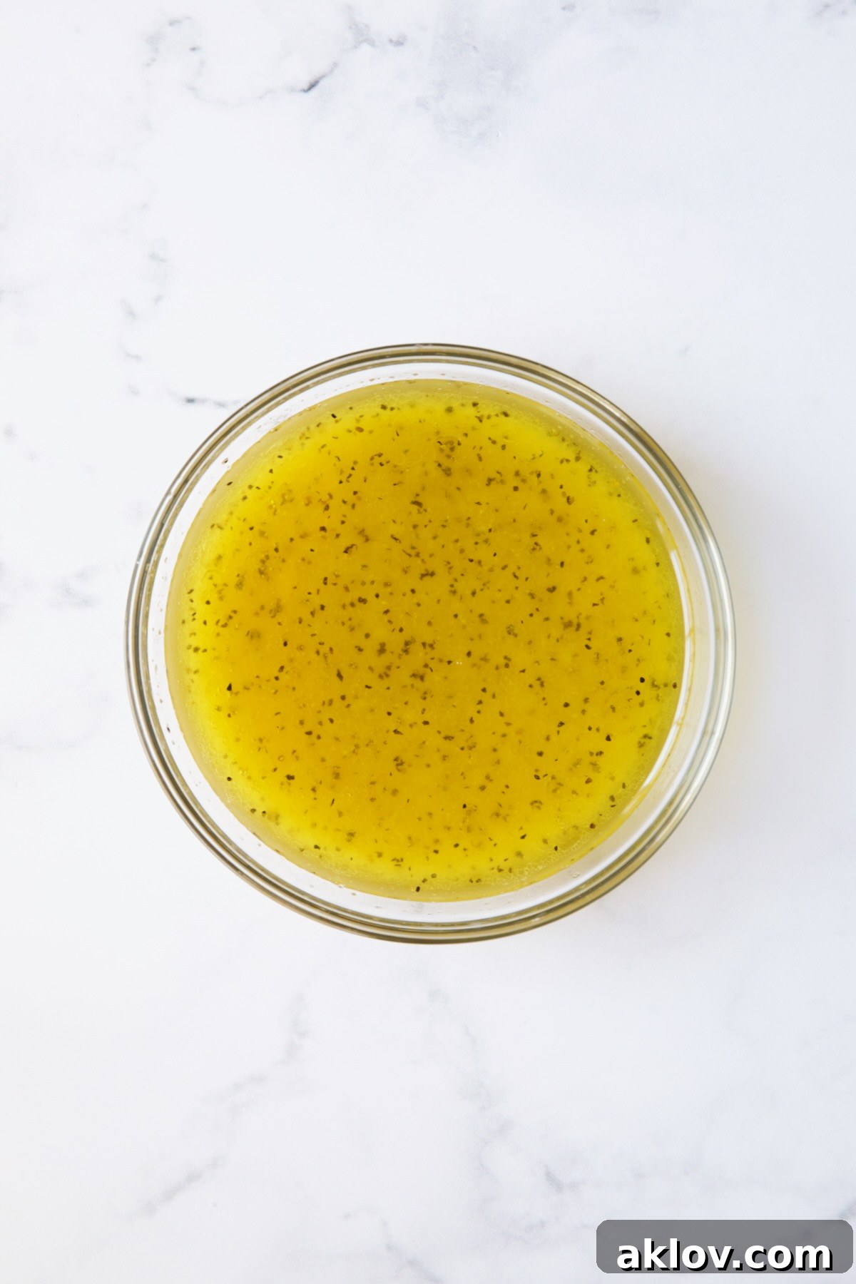 A small glass bowl filled with the freshly prepared Lemon Honey Dressing, smooth and ready to be drizzled.