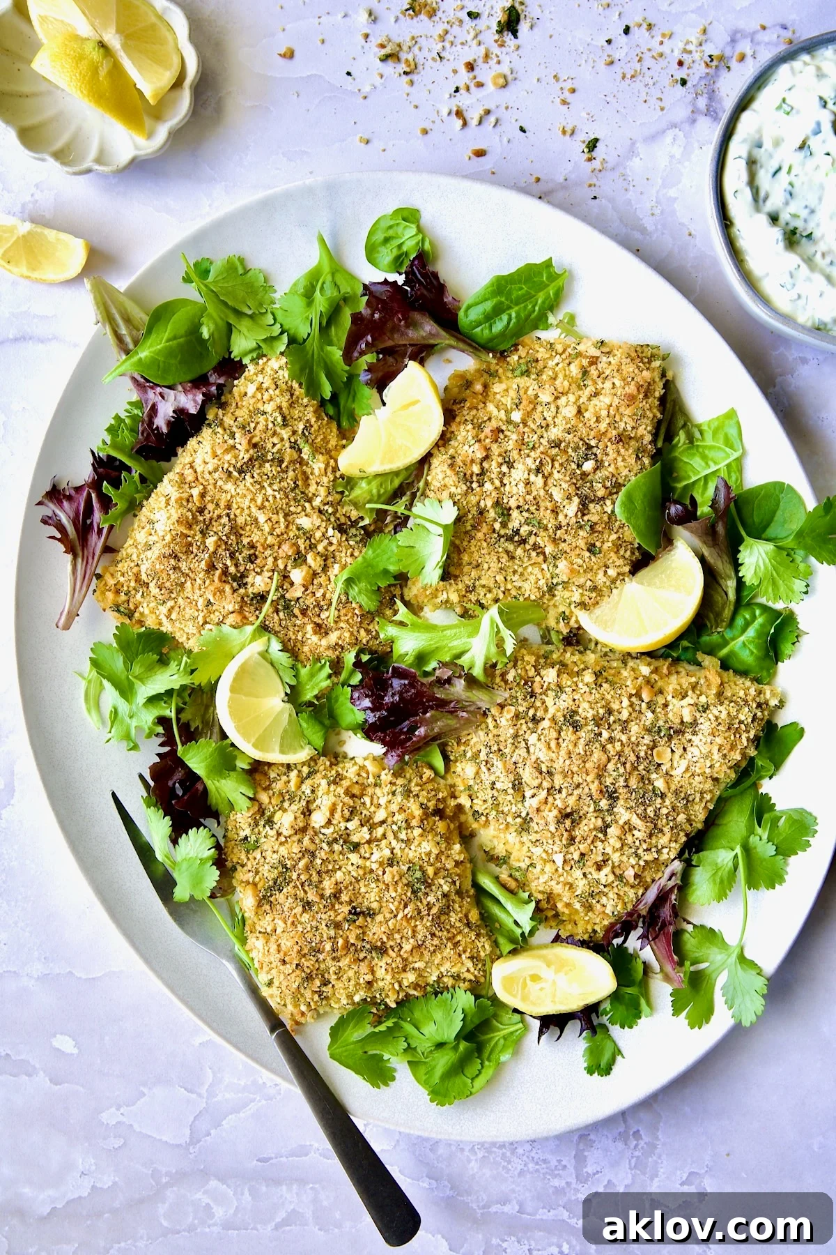 Crispy Chickpea-Crusted Fish with Zesty Jalapeno Tartar 2 Crispy Chickpea-Crusted Fish on oval white platter garnished with fresh baby greens, ready to be served.