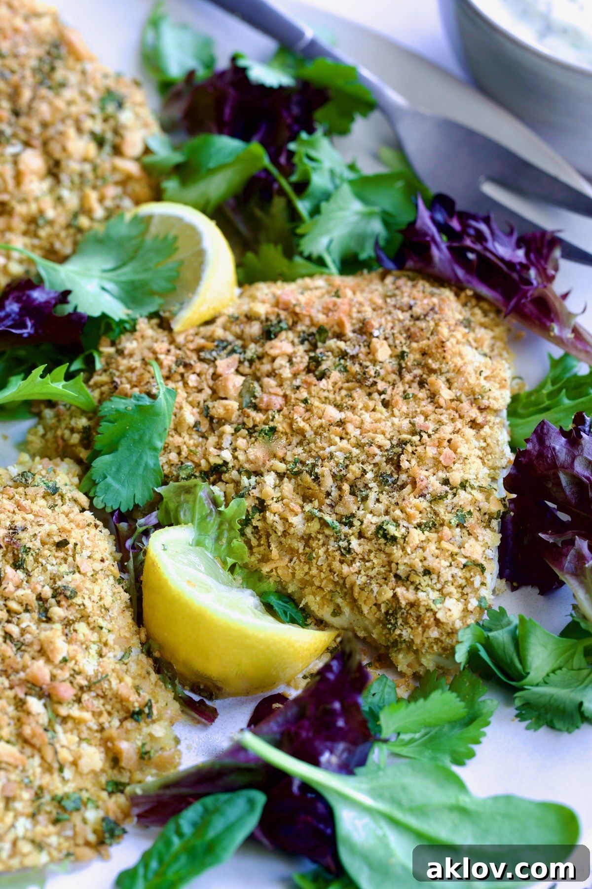 Crispy Chickpea-Crusted Fish with Zesty Jalapeno Tartar 13 A stunning presentation of Crispy Chickpea-Crusted Fish on an oval white platter, beautifully garnished with fresh baby greens.