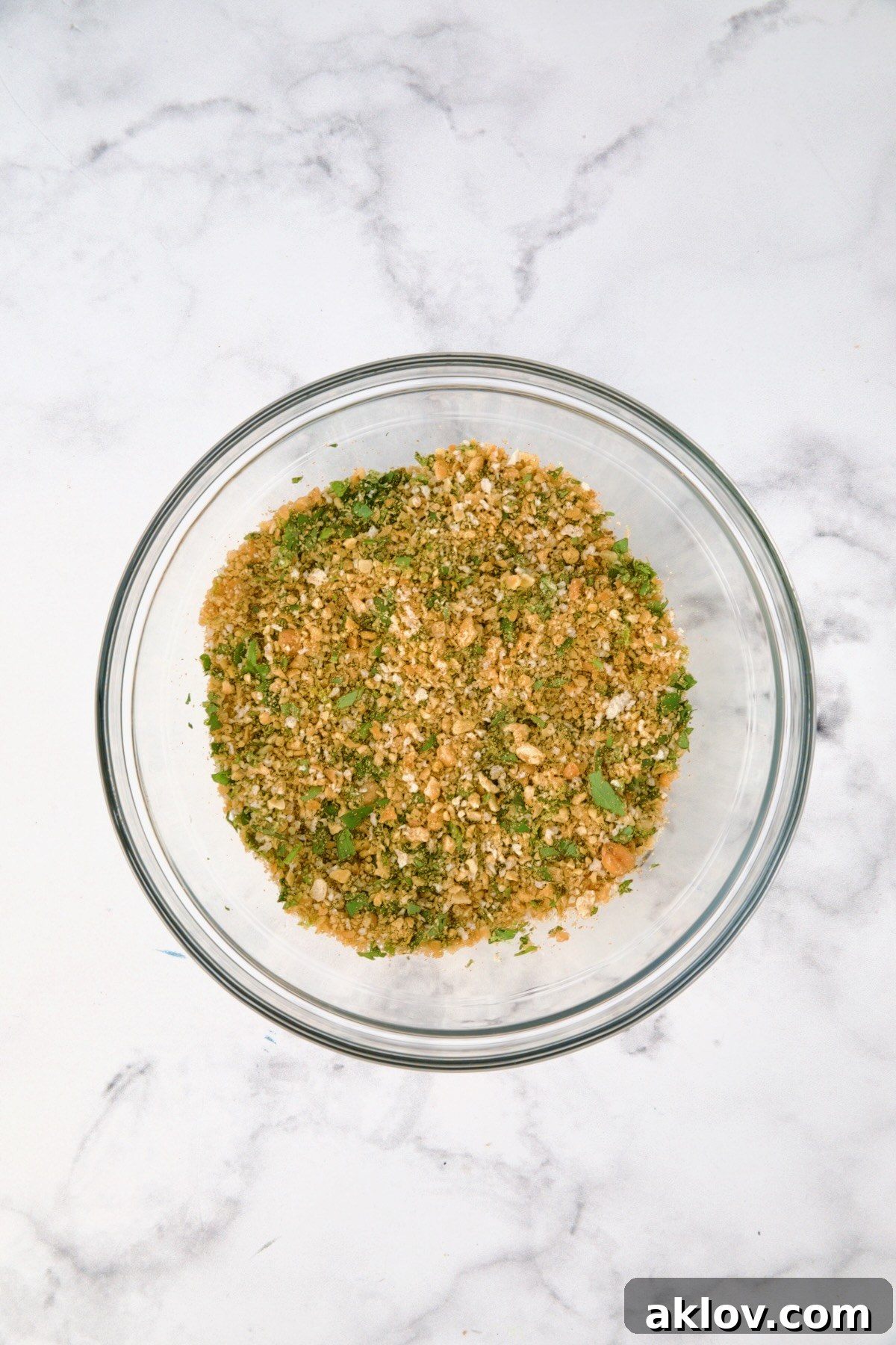 Crispy Chickpea-Crusted Fish with Zesty Jalapeno Tartar 8 The chickpea topping ingredients, including curry powder, panko, lime zest, and cilantro, are thoroughly combined in a glass bowl.