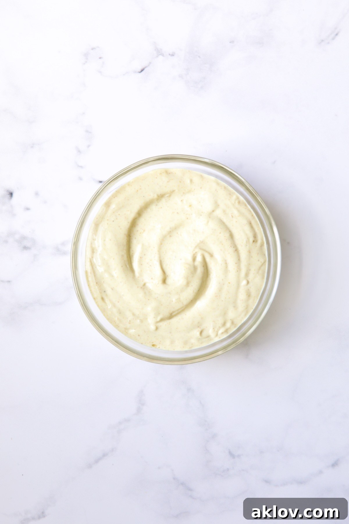 Bowl of Lemon Curry Mayonnaise in glass bowl.
