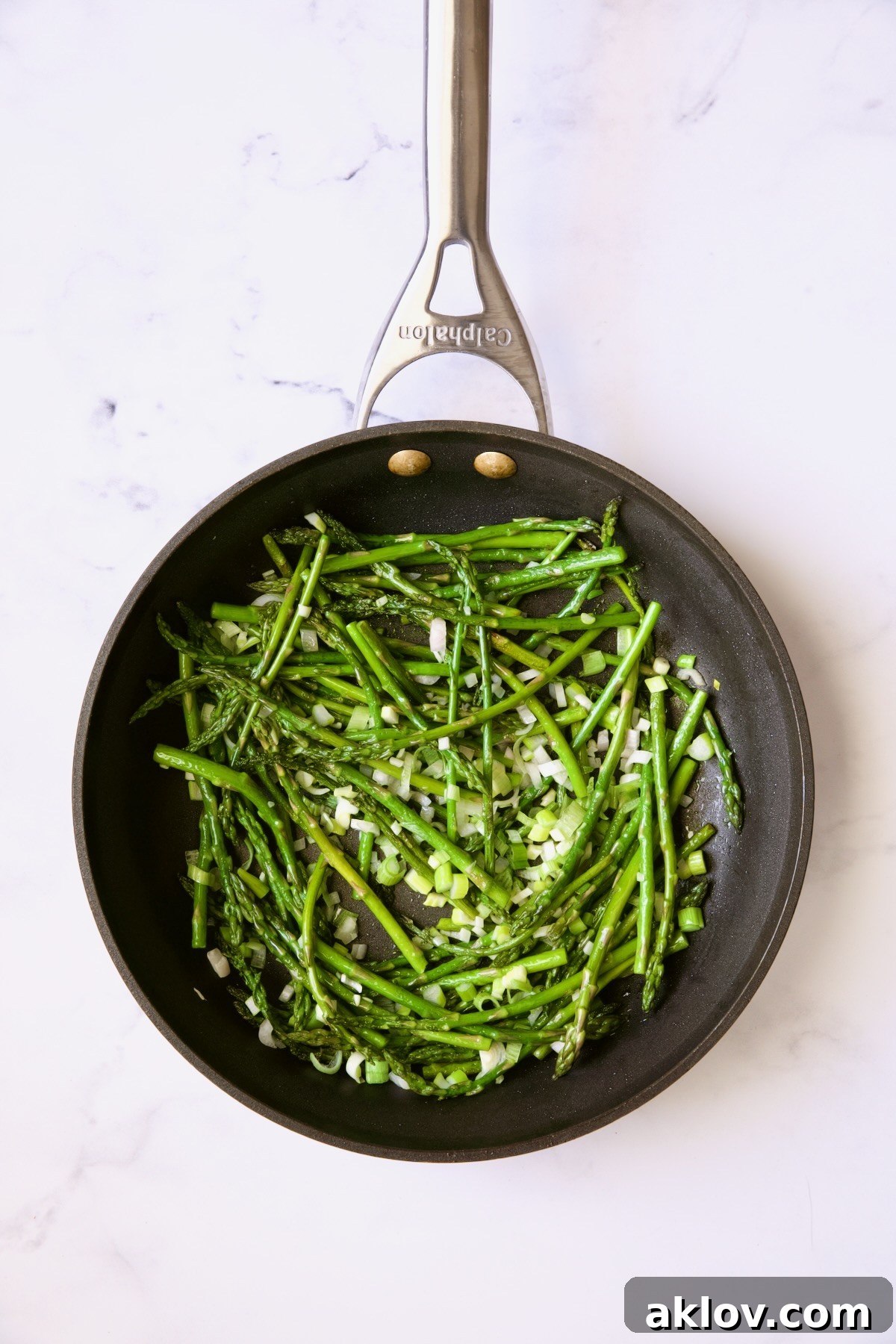 Cooked asparagus and scallions in nonstick skillet.