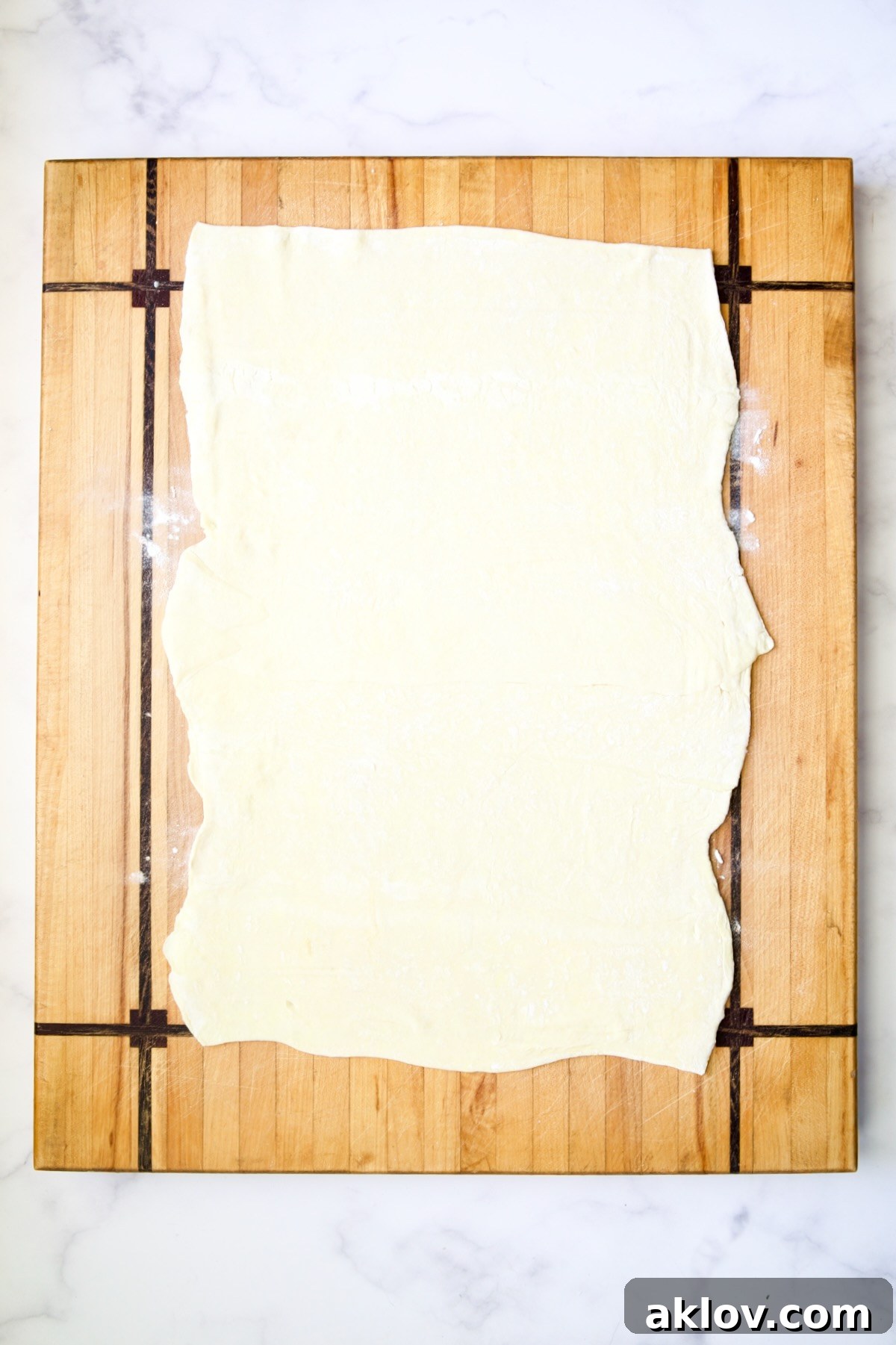 Puff pastry on wood cutting board.