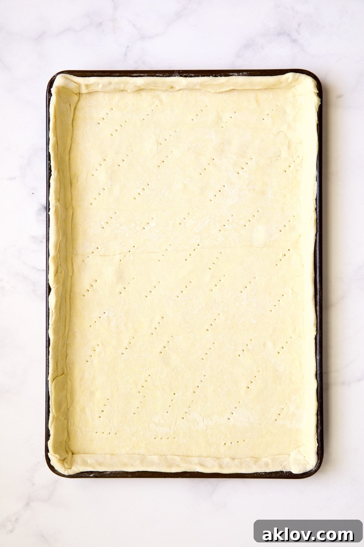 Puff pastry crust docked with fork holes.