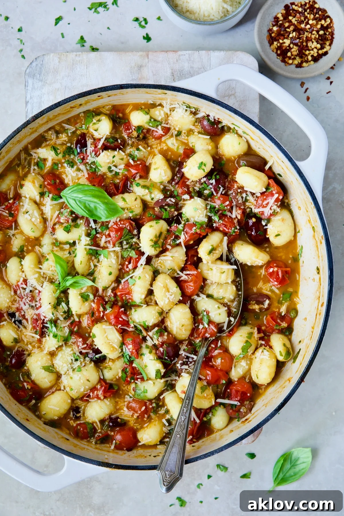Gnocchi with Cherry Tomato Puttanesca Sauce garnished with fresh parsley, basil and Parmesan cheese.