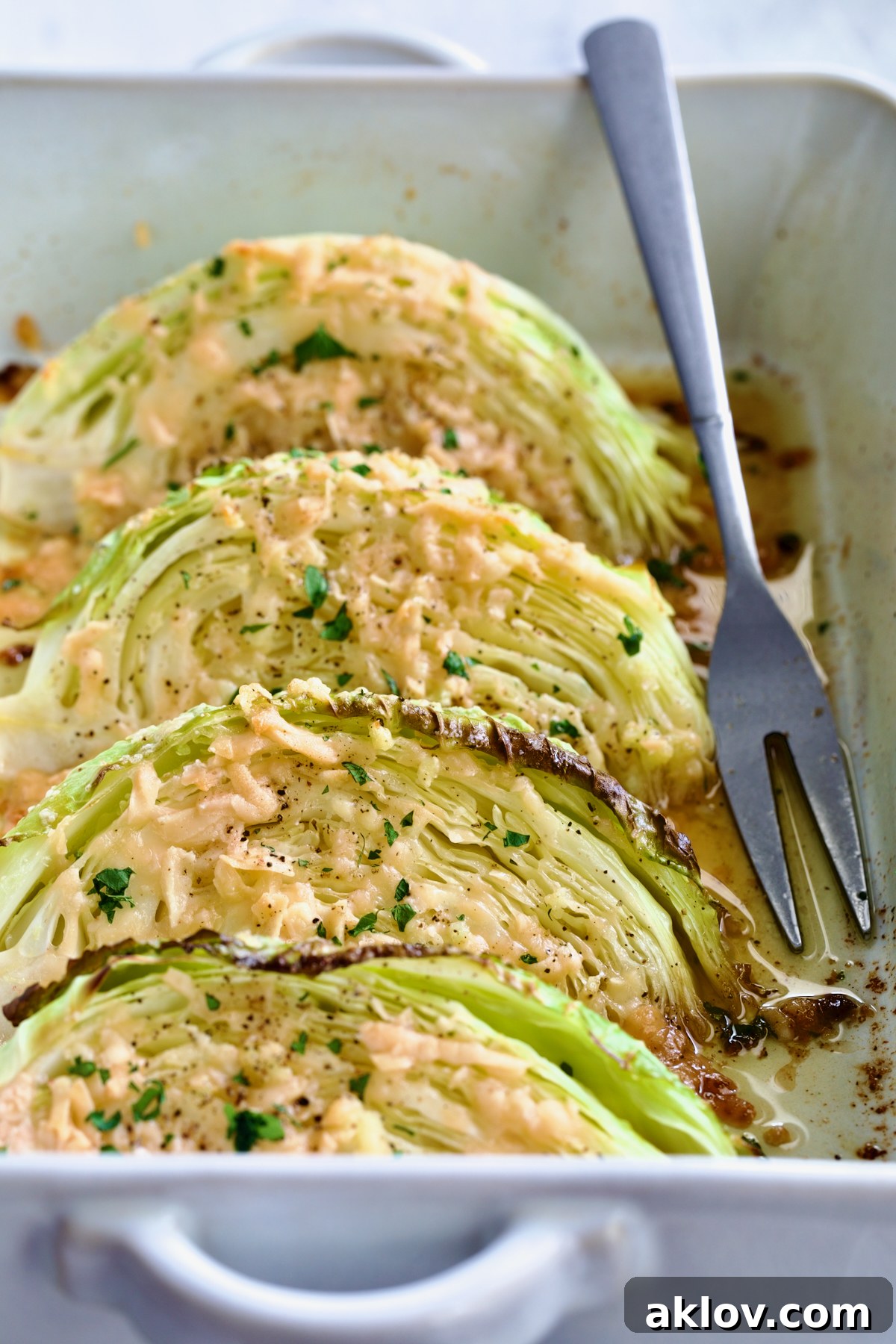 Baked Garlic Parmesan Cabbage Wedges elegantly arranged in a white baking dish.