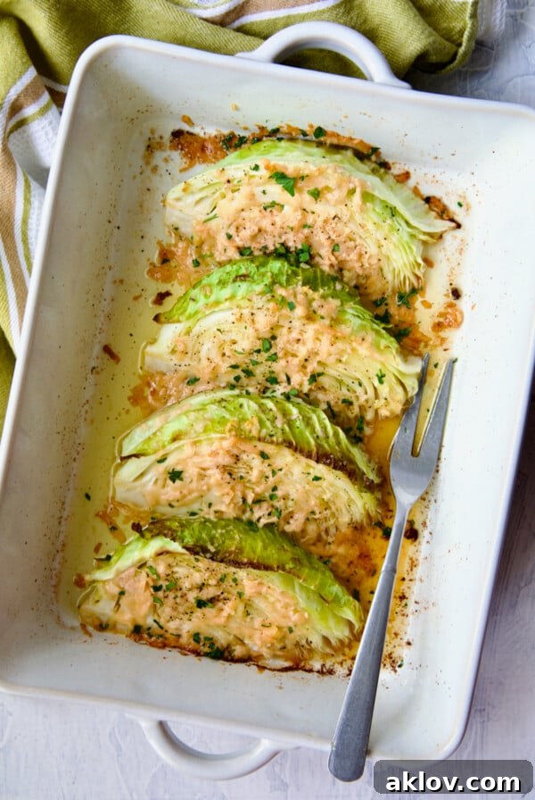 Baked Cabbage with Garlic and Parmesan in white baking dish with serving fork.