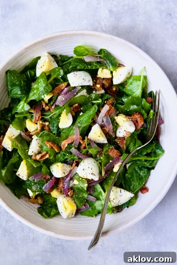 Radish Greens Salad with Hot Bacon Dressing in white serving bowl with serving fork.