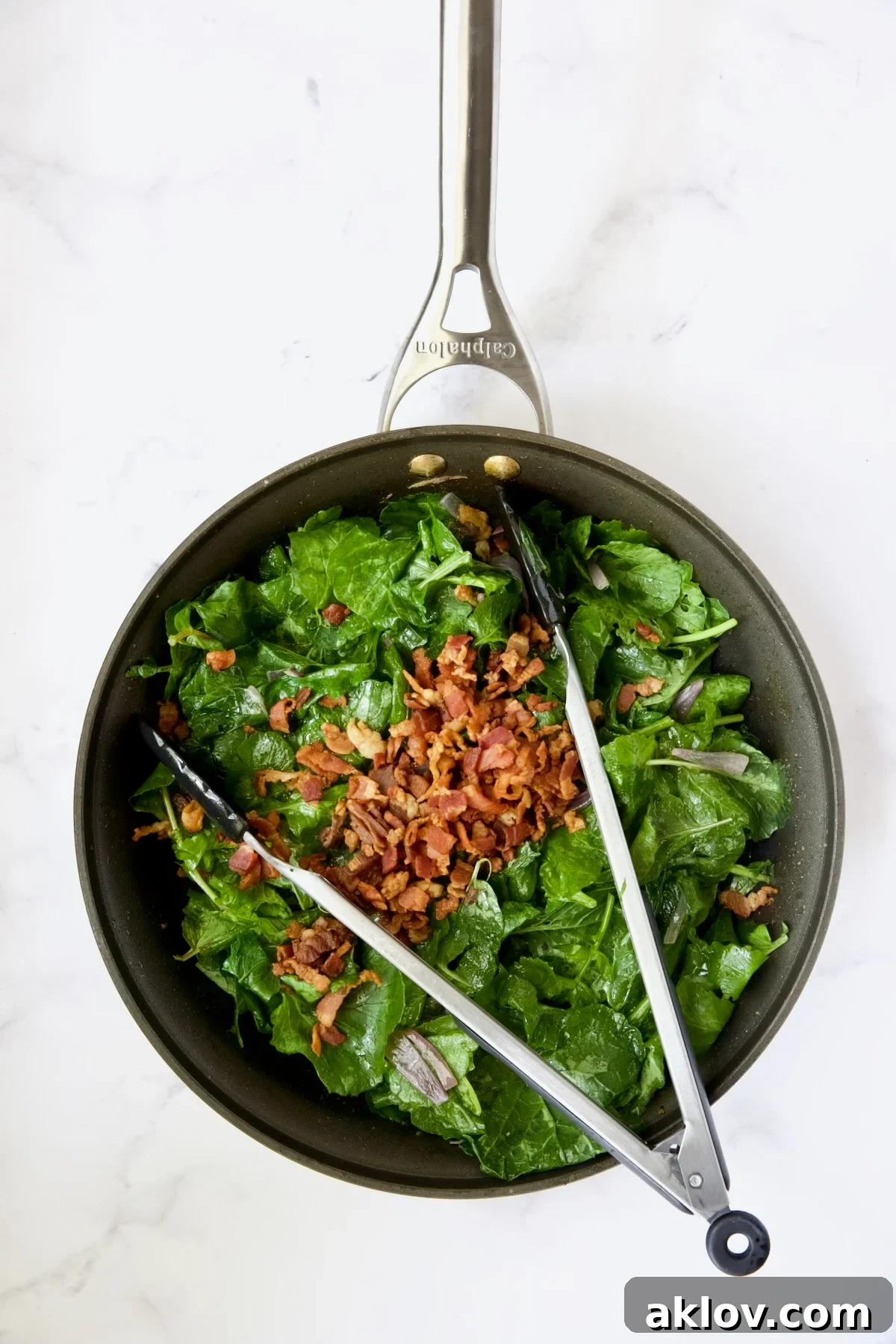 Slightly wilted radish greens in a skillet, now mixed with crispy bacon bits.