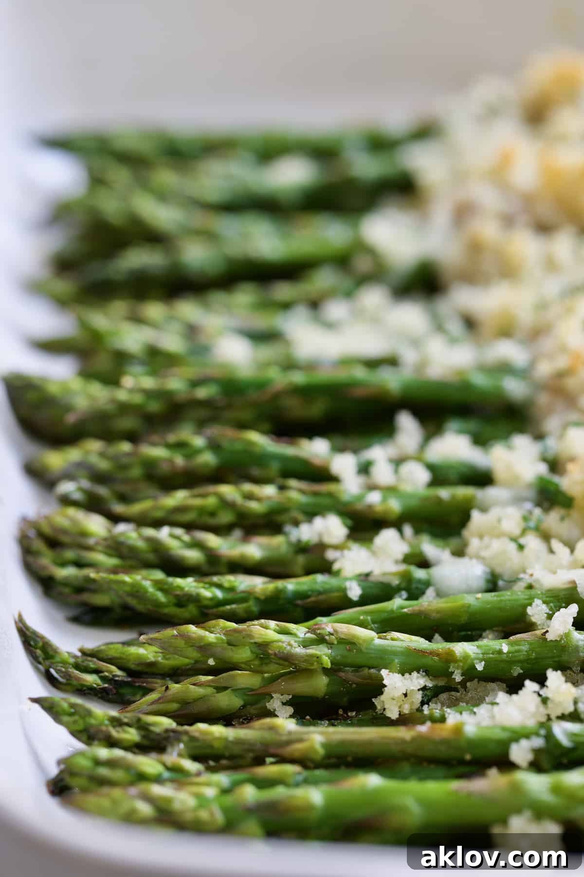 Close-up photo of Asparagus Cordon Bleu in white baking dish.
