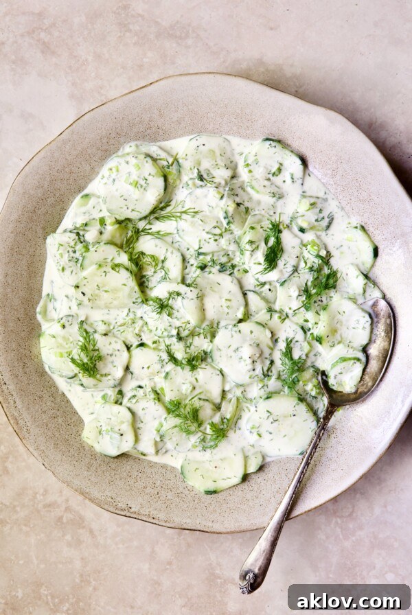 Creamy Cucumber Salad with Yogurt served in a charming serving bowl with an antique serving spoon.