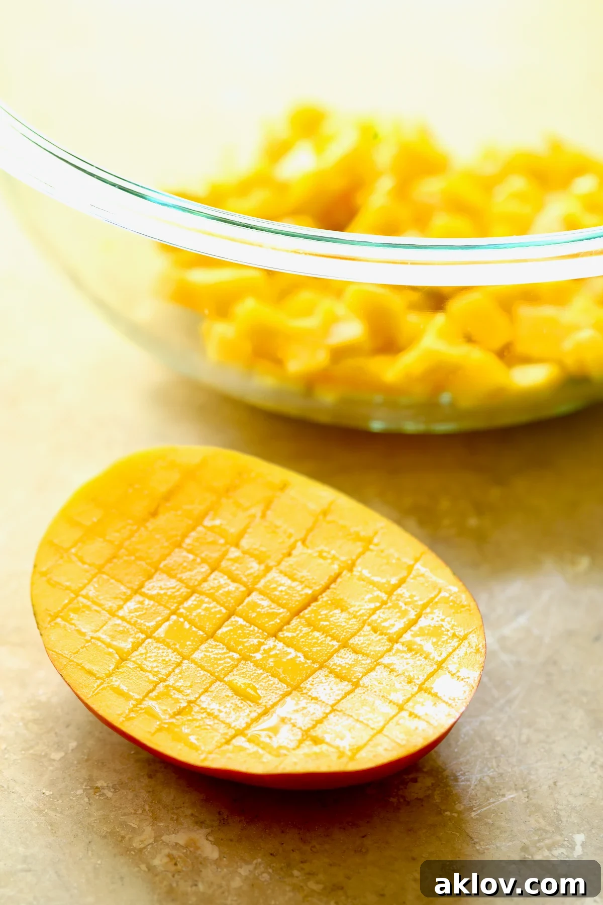 A visual guide demonstrating the technique for easily dicing a mango by scoring the flesh in a crosshatch pattern and then inverting the peel.